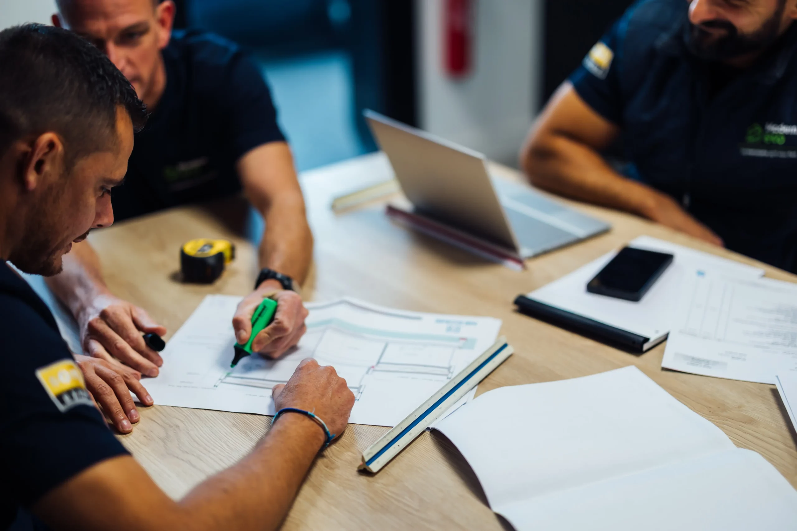 Équipe Modern Eco en réunion de conception autour de plans techniques de menuiseries